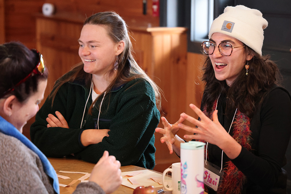 Three people have an animated discussion around a table