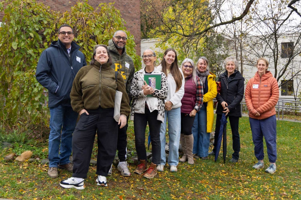 A group of people gather in front of a school.
