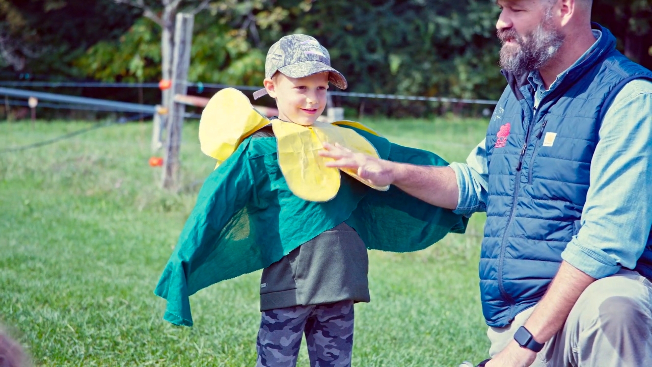 A young boy dresses up as a pea plant.