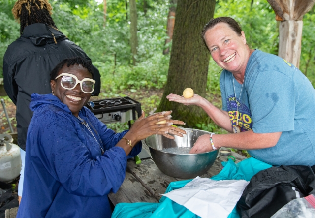 Two educators make butter by hand