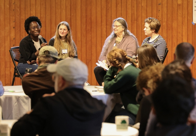 Four women sit on a small stage in a panel discussion