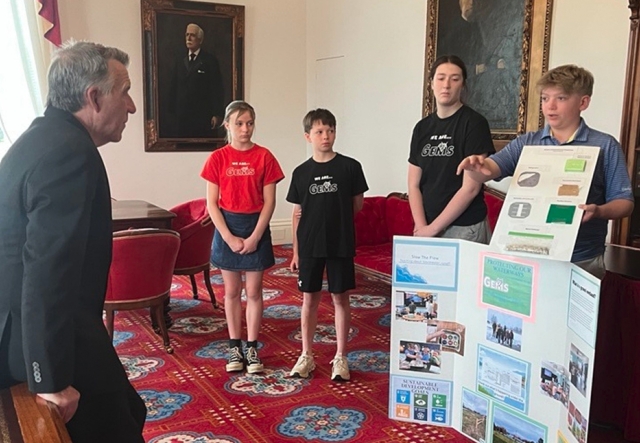 students and governor phil scott in discussion in his office