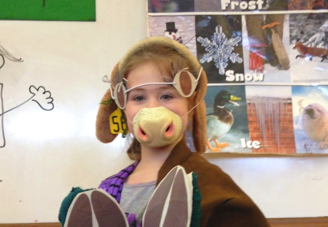 A young student stands in a classroom dressed up as a cow