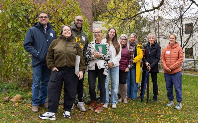 A group of people gather in front of a school.